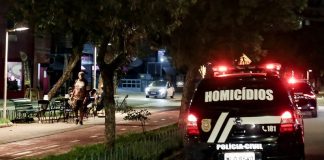 viatura da polícia civil com a inscrição "homicídios" passa por avenida com calçadão à noite -Crimes violentos em Santa Catarina