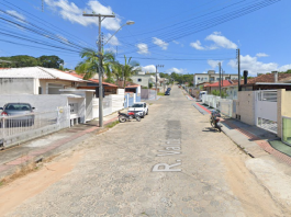 Imagem da rua em Forquilhas que passará por obras de pavimentação. A rua tem paralelepípedos e o céu está azul.