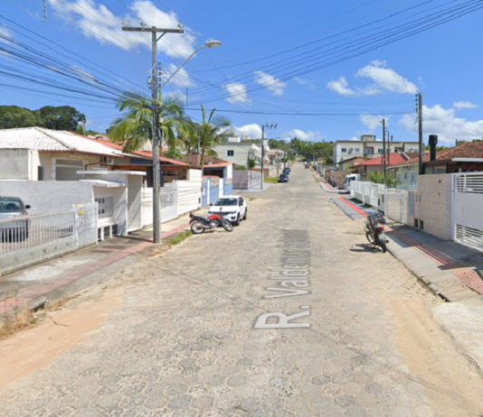 Imagem da rua em Forquilhas que passará por obras de pavimentação. A rua tem paralelepípedos e o céu está azul.