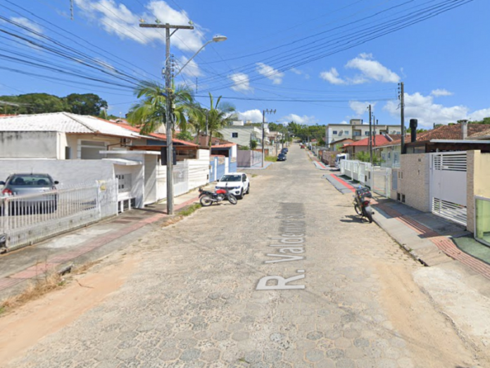 Imagem da rua em Forquilhas que passará por obras de pavimentação. A rua tem paralelepípedos e o céu está azul.