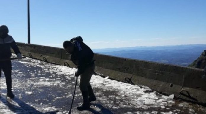 homem retira com pá gelo na pista da serra do rio do rastro - Congelamento da pista fecha tráfego na Serra do Rio do Rastro