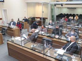 Vereadores da oposição na capital acusam prefeito de copiar projetos do legislativo vereadores sentados nas bancadas da câmara de florianópolis separados por vidros, usando máscaras