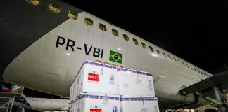 caixas de isopor em frente a um avião na chegada de parte do lote de 316 mil novas doses de vacinas contra covid para sc