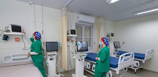 Santa Catarina está sem fila por leitos de UTI duas enfermeiras arrumam equipamentos ao lado de camas - Santa Catarina está sem fila por leitos de UTI