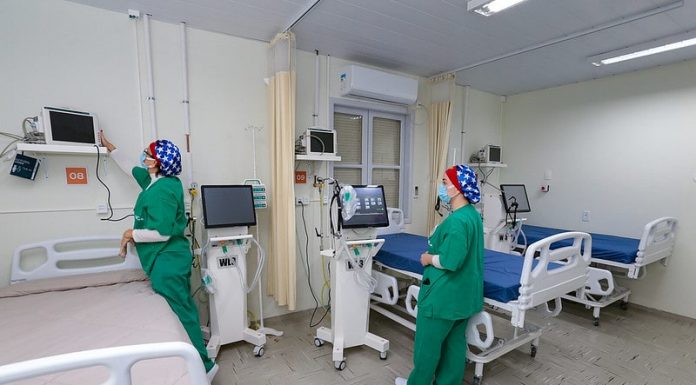 duas enfermeiras arrumam equipamentos ao lado de camas - Santa Catarina está sem fila por leitos de UTI