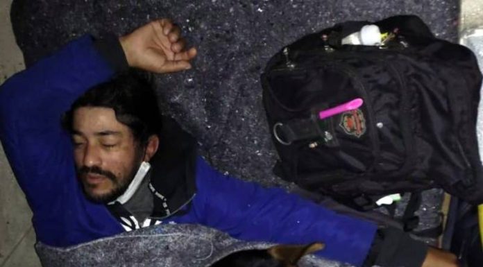 homem dorme com cachorro em cama no chão - Moradores de rua são acolhidos em hotel em Florianópolis