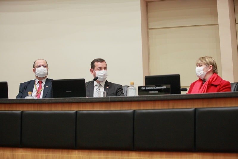 eron giordani, chefe da casa civil, em bancada ao lado de luciane carminatti; todos de máscara