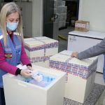funcionários de colete e máscara separam 379 mil doses da vacina contra a Covid-19 chegaram a Santa Catarina