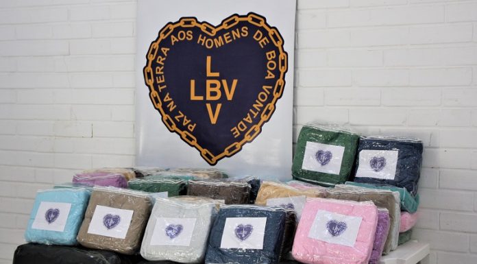 Cobertores coloridos e embalados aparecem enfileirados e acima um coração identifica a LBV. Os cobertores serão doados ao centro pop de são josé