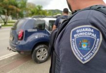 guarda municipal de florianópolis distintivo no braço de agente e viatura ao fundo - criação da corregedoria é aprovada