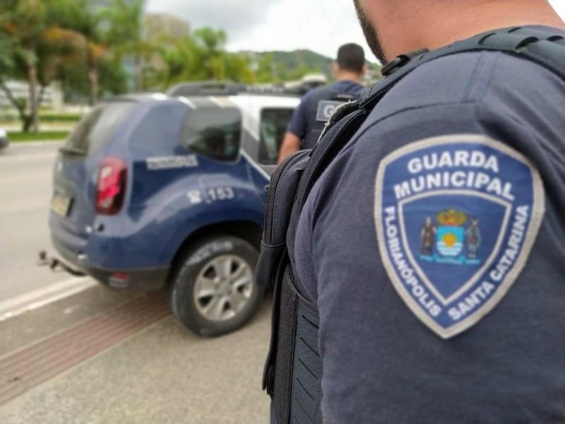 guarda municipal de florianópolis distintivo no braço de agente e viatura ao fundo - criação da corregedoria é aprovada