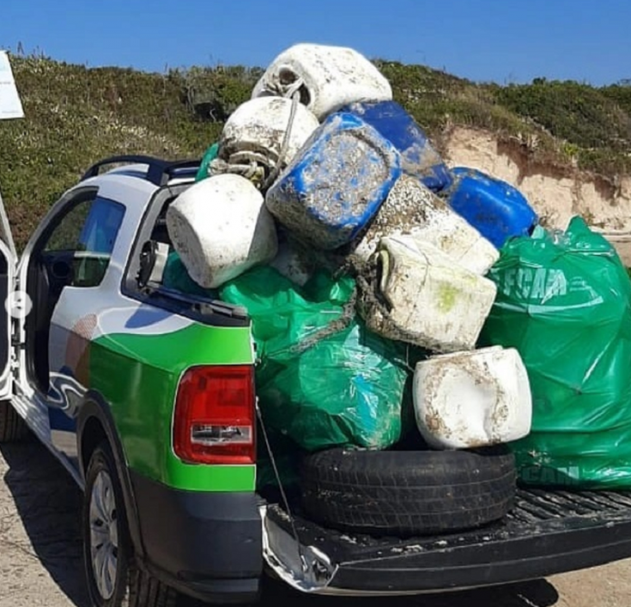 Mutirão recolhe mais de 100 quilos de lixo na orla de Palhoça - caminhonete estacionada em praia com caçamba repleta de sacos de lixo empilhados após mutirão