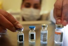 pessoas usando máscara mexe em 4 ampolas de vacinas - Santa Catarina aplicou mais de 4 milhões de vacinas contra Covid-19