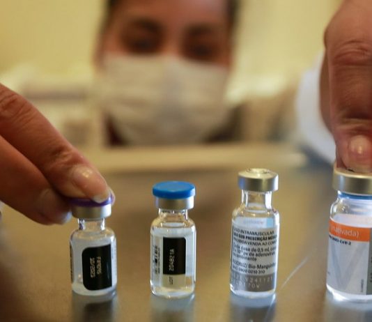 Terceira dose é liberada para toda população adulta pessoas usando máscara mexe em 4 ampolas de vacinas - Santa Catarina aplicou mais de 4 milhões de vacinas contra Covid-19