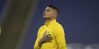 zagueiro thiago silva canta o hino com mão sobre brasão da cbf