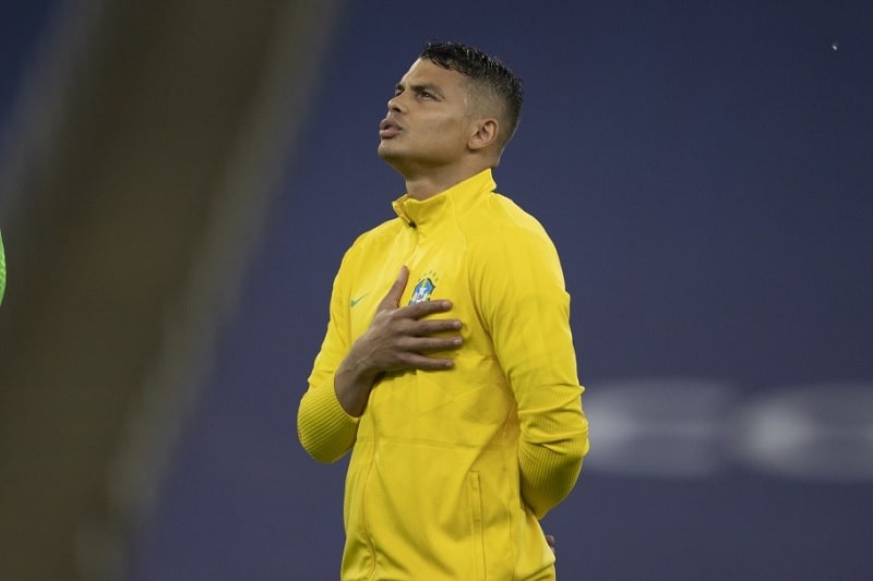 zagueiro thiago silva canta o hino com mão sobre brasão da cbf