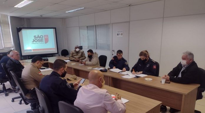 Em duas mesas separadas, sentados frente a frente, o secretário de segurança e representantes do comércio e forças de São José discutem o plano de metas para segurança de São José, que conta com ampliação do videomonitoramento em São José