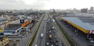 Foto de cima mostra as pistas com movimentação de carros e nas laterais prédios. A Arteris liberou 5 km da nova terceira faixa em trecho em São José.