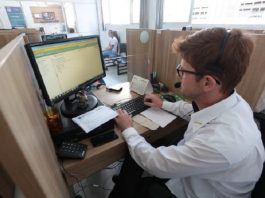 homem de camisa branca, sentado trabalhando em um computador