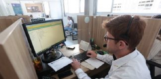 homem de camisa branca, sentado trabalhando em um computador