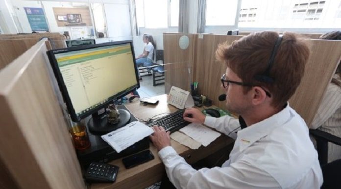 homem de camisa branca, sentado trabalhando em um computador