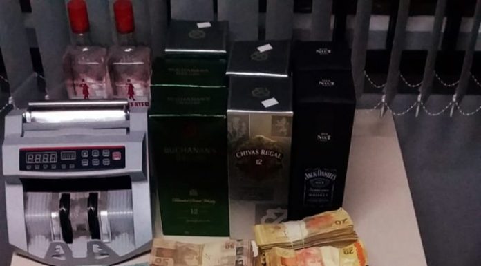 notas de dinheiro e outros objetos organizados sobre mesa - Polícia apreende R$ 347 mil do tráfico em kitnet em São José