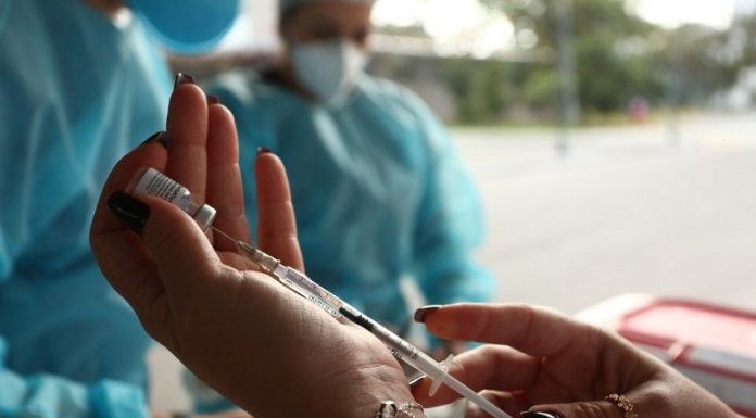 São José e Florianópolis vacinam população com mais de 18 anos profissional retira dose de vacina de ampola com setinga - são josé e florianópolis vacinação população acima de 18 anos contra covid