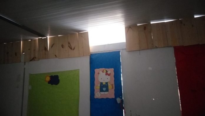A foto mostra uma parede com o desenho da personagem hello kitty e acima há pedaços de madeira fechando um espaço, a exceção de um ponto em que não há madeira. A creche filantrópica de São José passa por uma semana de assaltos e arrombamentos.