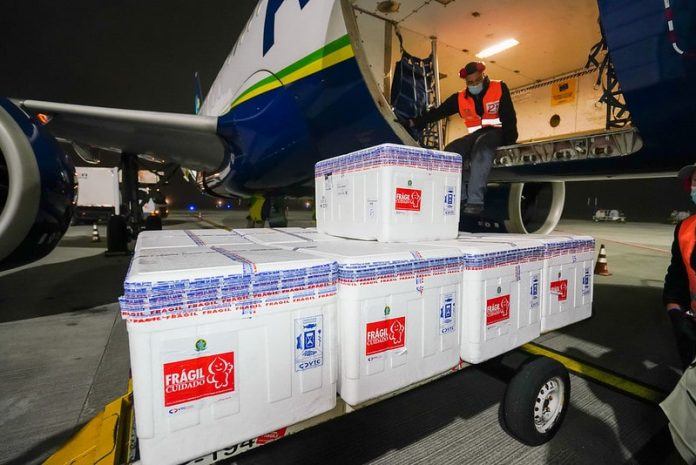 doses da vacina contra coronavírus são distribuídas em caixas de isopor saindo de avião