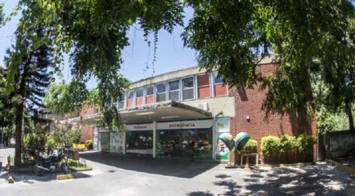 Hospital Infantil suspende cirurgias eletivas por um dia Entrada da emergência do hospital infantil, com portas de vidro e prédio de tijolo a vista. Nesta semana, o Hospital Infantil Joana de Gusmão suspendeu as cirurgias eletivas por risco de falta de insumos.