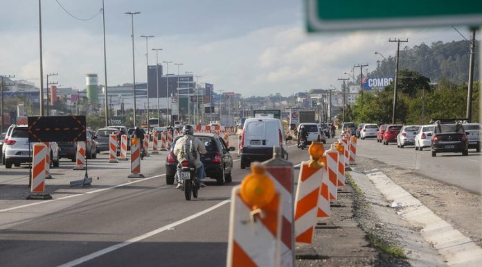 moto acessa marginal da br-101 atrás de fluxo de veículos com sinalização emergencial ao redoro