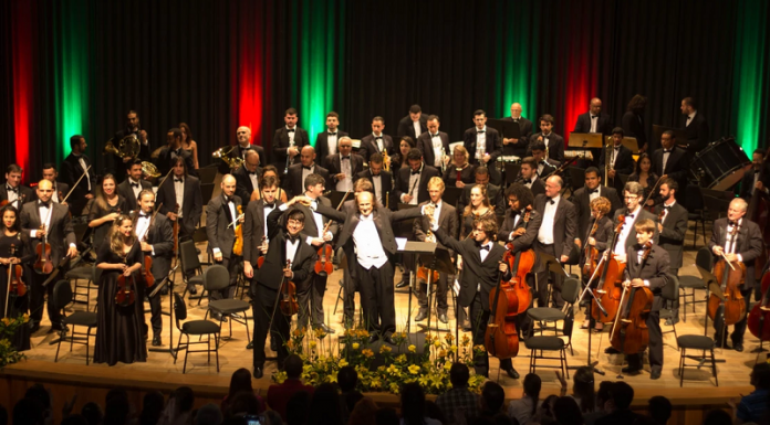 No palco, os músicos da orquestra sinfônica de sc (ossca) vestem terno escuro com camiseta branca e estão próximos aos seus instrumentos. A orquestra retorna aos palcos com o concerto beethoven 250, em são josé.