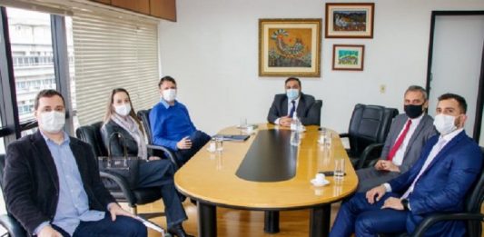 PGE faz nova investida para recuperar R$ 19 milhões dos respiradores da Veigamed Seis pessoas sentadas ao redor de uma mesa amarela. Eles discutem ações de recuperação do dinheiro investido na compra dos respiradores em SC, iniciativa da PGE/SC.