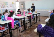professora em sala de auala com alunas sentadas - Aprovado aumento salarial para 49 mil profissionais da educação estadual