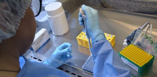 profissional com epi maneja ampolas em laboratório - Com 36 casos, SC alerta para medidas de prevenção contra variante Delta