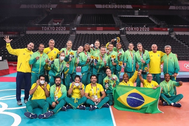 time de vôlei feminino do brasil posa com unforme e medalha de prata na quadra tóquio 2020