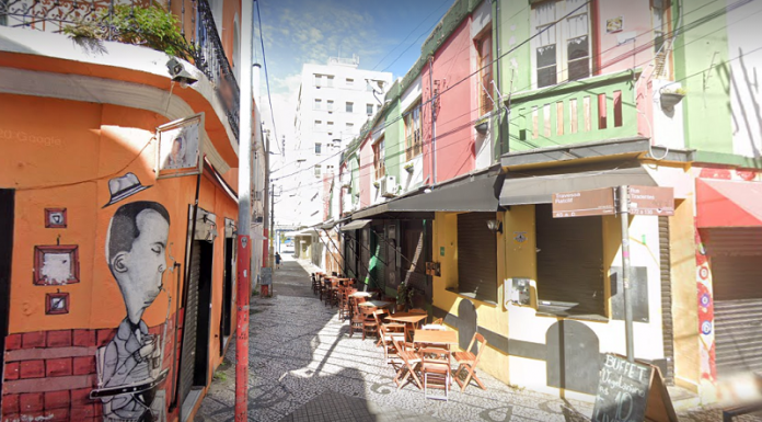 A imagem mostra uma travessa com mesas de bar na rua, vazia, em meio a prédios coloridos. Entidades empresariais questionam o passaporte de vacina em Florianópolis, que deve exigir vacinação para acesso a bares, restaurantes e eventos.