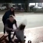 Frame de um vídeo que mostra as agressões de um homem contra outro homem. Na imagem, a vítima é jogada no chão pelo agressor, enquanto uma mulher observa e tenta se aproximar. O caso é tratado como suspeita de homofobia e ocorreu em Jaraguá do Sul.