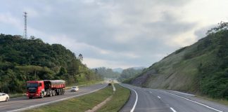 Trecho da BR-470 em SC, com uma pista cinza com marcas brancas à direita, uma parte com grama ao centro e à esquerda outra pista, com carros e um caminhão. O governador Carlos Moisés envia à Alesc o PL para doação de mais R$115 milhões para obras em rodovias federais.