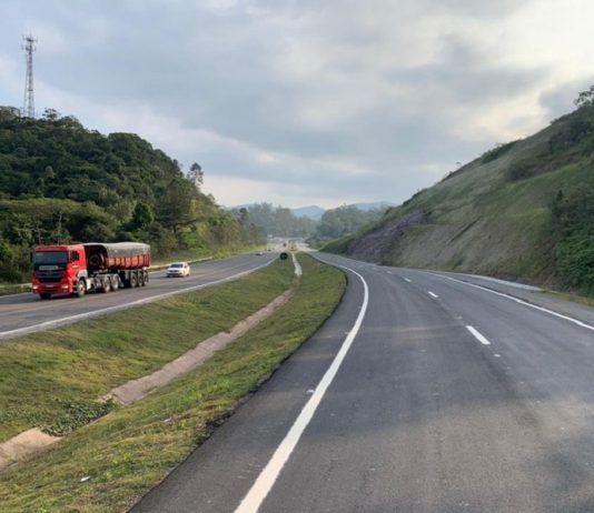 Trecho da BR-470 em SC, com uma pista cinza com marcas brancas à direita, uma parte com grama ao centro e à esquerda outra pista, com carros e um caminhão. O governador Carlos Moisés envia à Alesc o PL para doação de mais R$115 milhões para obras em rodovias federais.