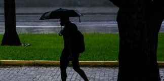 clima para amanhã - previsão do tempo santa catarina - chuva - silhueta de pessoa andando com guarda-chuva