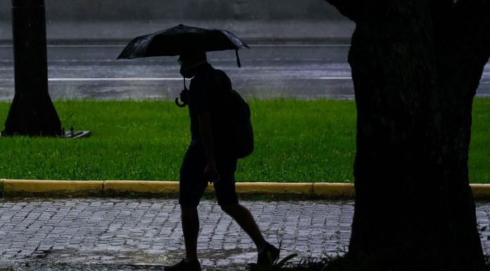 clima para amanhã - previsão do tempo santa catarina - chuva - silhueta de pessoa andando com guarda-chuva