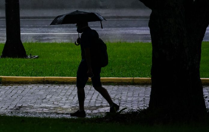 clima para amanhã - previsão do tempo santa catarina - chuva - silhueta de pessoa andando com guarda-chuva