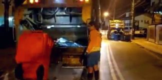 duas equipes de coleta de lixo na mesma rua em florianópolis, uma da comcap, outra da terceirizada, ao fundo