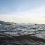 barcos na lagoa da conceição, em florianópolis, com montanhas ao fundo