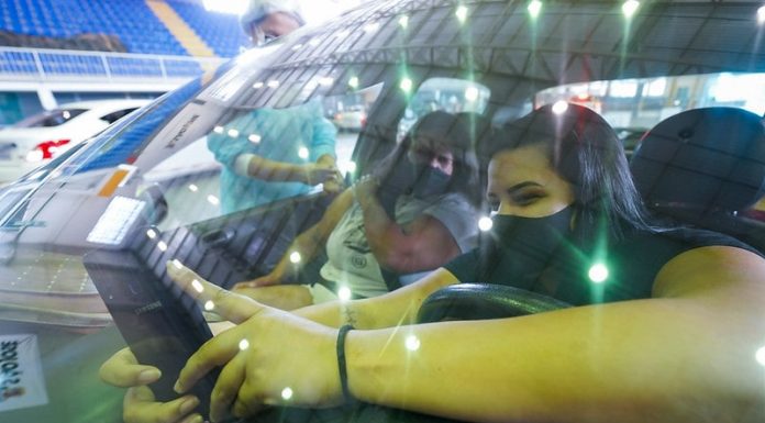 pessoas fazendo selfe dentro de carro quando recebendo vacina contra covid no centro multiuso de são josé