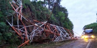 Torre de emissora de rádio desaba na BR-282 em Xaxim - estrutura colapsada sobre meia pista da rodovia em trecho ligeiramente curvo e com paradão de pedra ao lado