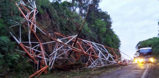 Torre de emissora de rádio desaba na BR-282 em Xaxim - estrutura colapsada sobre meia pista da rodovia em trecho ligeiramente curvo e com paradão de pedra ao lado
