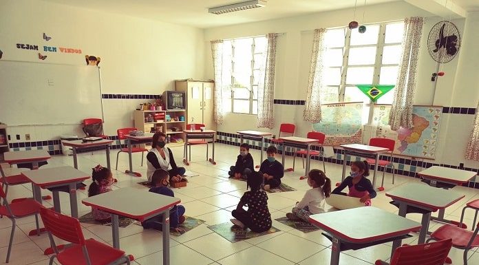 estudantes sentados em roda no chão da sala