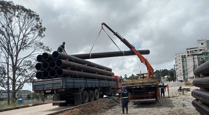 Casan inicia implantação de emissário no trecho em duplicação na Edu Vieira - caminhão munck retira canos de outro caminhão